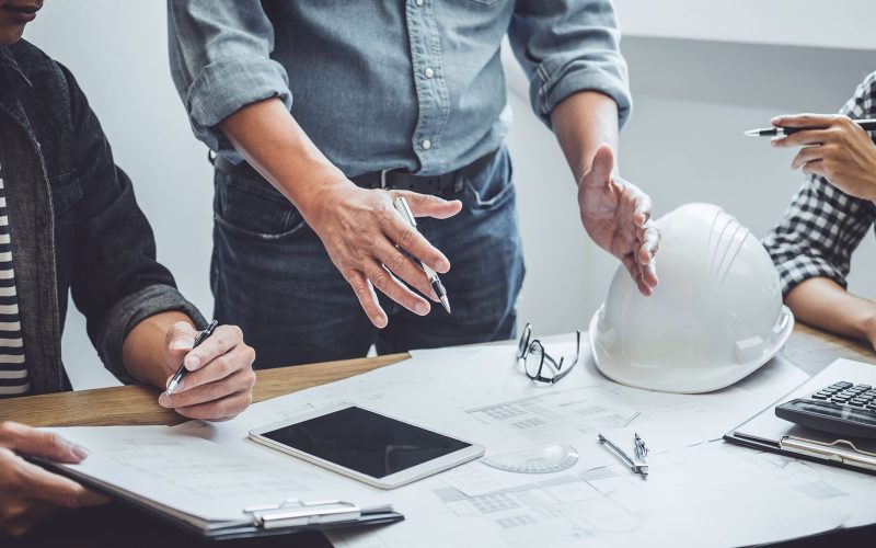 Construction and structure concept of Engineer or architect meeting for project working with partner and engineering tools on model building and blueprint in working site, contract for both companies.