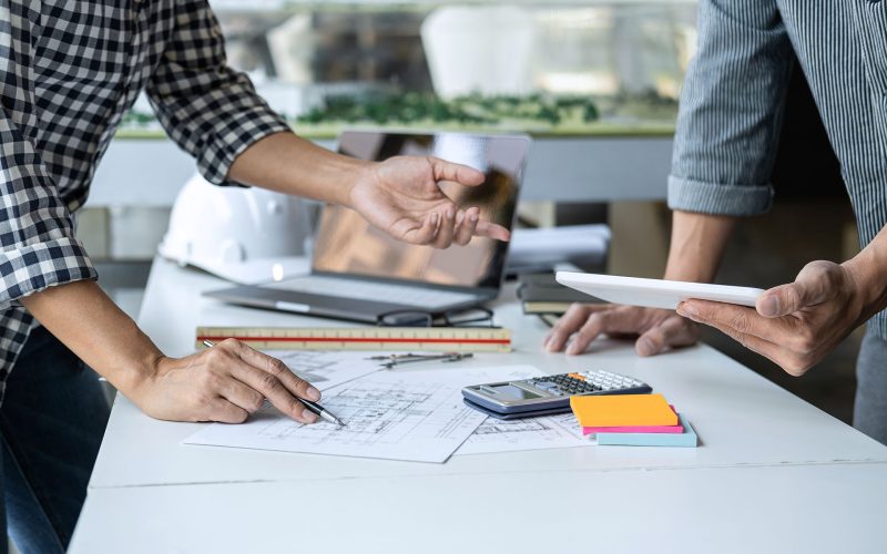 Construction and structure concept of Engineer or architect meeting for project working with partner and engineering tools on model building and blueprint in working site, contract for both companies.